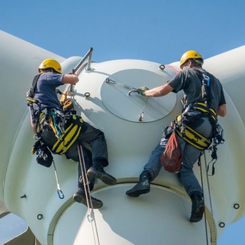 Techniciens au sommet d'une éolienne pour des réparations