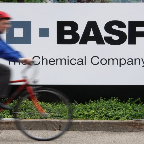 A cyclist rides his bike bast the entrance of the BASF plant in Schweizerhalle