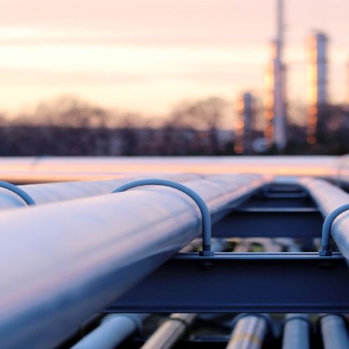 steel long pipes in crude oil factory during sunset